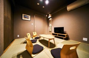 a living room with chairs and a table and a tv at Bon in Kyoto