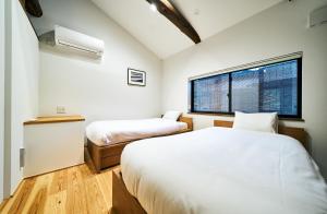 1 dormitorio con 2 camas y ventana en Bon en Kioto