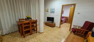 sala de estar con TV, mesa y silla en Apartamentos Bellavista, en Puerto de Mazarrón