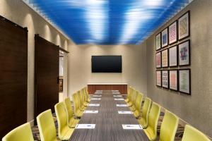 a conference room with a long table and yellow chairs at Holiday Inn Express Hotel & Suites Pigeon Forge, an IHG Hotel in Pigeon Forge