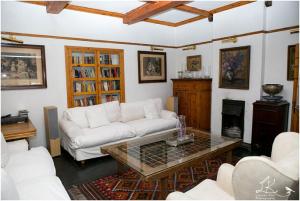 uma sala de estar com um sofá branco e uma mesa em Sandton Farmhouse em Joanesburgo