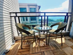 een balkon met 2 stoelen en een glazen tafel bij 3Kiss Homestay in Wujie
