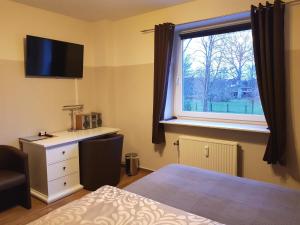 Schlafzimmer mit einem Bett und einem Fenster in der Unterkunft Flensburg Ferienwohnungen Apartment 1 in Flensburg