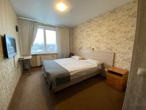 a small bedroom with a bed and a window at Hotel Chemodan in Pskov