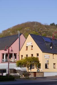 a building with a mountain in the background at Moselblick Hotel Aroma in Burgen +35 photos
