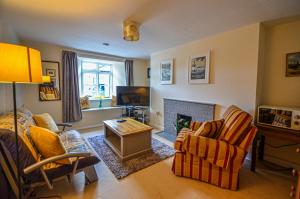 a living room with a couch and chairs and a fireplace at The Annex at Middle Filham, Ivybridge in Ivybridge