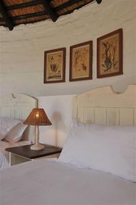 a bedroom with a bed and a table with a lamp at De Hoop Collection - Campsite Rondawels in De Hoop Nature Reserve +22 photos