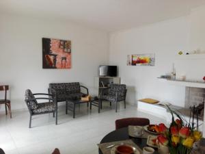 a living room with several chairs and a table at Oasi tra gli Ulivi in Carovigno