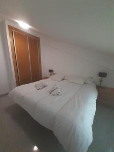 ein Schlafzimmer mit einem großen weißen Bett mit zwei Handtüchern darauf in der Unterkunft EL ATICO DE FUENGIROLA in Fuengirola
