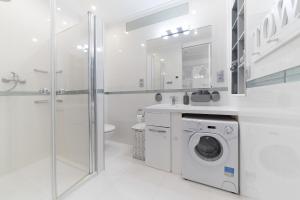 biała łazienka z pralką i prysznicem w obiekcie Blue Bay w Juracie +12 zdjęć