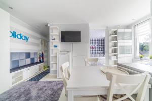 biała jadalnia z białym stołem i krzesłami w obiekcie Blue Bay w Juracie