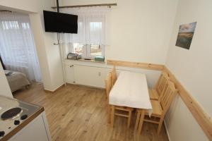 eine Küche und ein Esszimmer mit Tisch und Stühlen in der Unterkunft Wigierski Park Narodowy in Suwałki