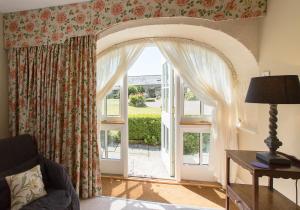 een woonkamer met een groot raam met gordijnen bij Shieldhall - Cabinetmakers Suite in Morpeth