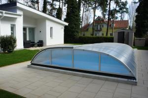 a swimming pool with a glass cover on a patio at Bori Villa Siófok in Siófok