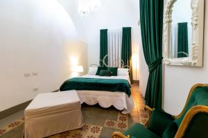 a bedroom with a bed with green curtains and a mirror at Pupi e Pupari in Catania