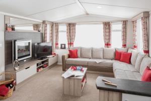 a living room with a couch and a tv at Camping 't Veerse Meer in Wolphaartsdijk