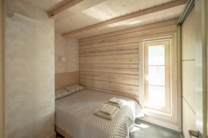 ein kleines Schlafzimmer mit einem Bett und einem Fenster in der Unterkunft VieniKrante in Utena