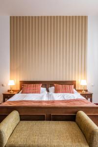 克羅梅日什的住宿－Hotel U Zlatého kohouta，一间卧室配有一张大床和两把椅子
