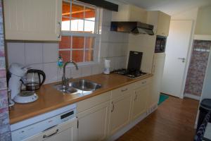 a kitchen with a sink and a counter top at dutchduochalet37 in 's-Gravenzande