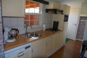 a kitchen with a sink and a counter top at dutchduochalet37 in s-Gravenzande