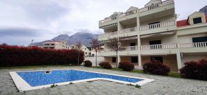a hotel with a swimming pool in front of a building at Apartment Veronika in Promajna
