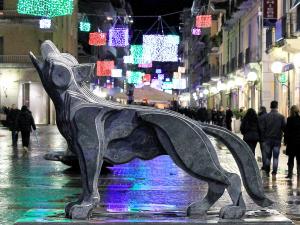 Una statua di un cane in una strada di notte di Italiana Hotels Cosenza a Cosenza