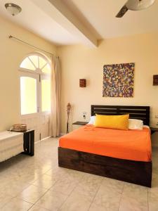 a bedroom with an orange bed and a window at Casa Bom Dia in Mindelo