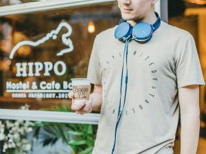 un uomo con le cuffie e una tazza di caffè di Hippo Hostel and Cafe Bar ad Osaka