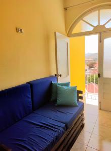 a blue couch in a room with a window at Casa Bom Dia in Mindelo