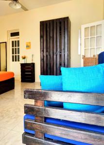 a bench in a living room with blue pillows at Casa Bom Dia in Mindelo