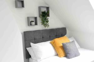 a gray headboard with pillows and a plant on it at The Social - Cardiff's Best For Larger Groups in Cardiff