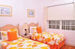 two beds sitting next to each other in a bedroom at Seagaze beach house is perfect for family, a few steps to the beach in Saint James