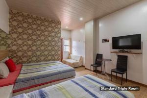 a bedroom with a bed and a flat screen tv at OYO 767 Hotel Urban - Khotel Kurban Hotel in Baguio