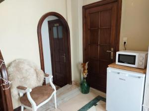 Pokój z kuchenką mikrofalową i krzesłem obok drzwi w obiekcie Le cocon w La-Roche-en-Ardenne