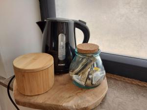 - une cafetière et un pot en verre sur une table en bois dans l'établissement Le cocon, à La-Roche-en-Ardenne