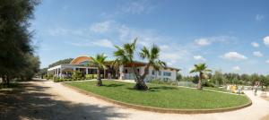 un edificio con delle palme di fronte di TIGLI Lido Altanea a Caorle