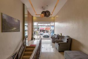 a hallway with couches and a staircase in a building at OYO 767 Hotel Urban - Khotel Kurban Hotel in Baguio