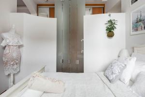 a white bedroom with a bed and a dresser at Old Town Square Apartment in Prague