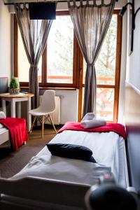 a bedroom with a bed and a large window at Pensjonat Maja in Nowy Sącz