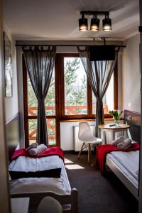 sypialnia z 2 łóżkami i oknem w obiekcie Pensjonat Maja w Nowym Sączu