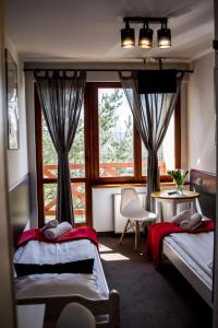 a bedroom with two beds and a window at Pensjonat Maja in Nowy Sącz