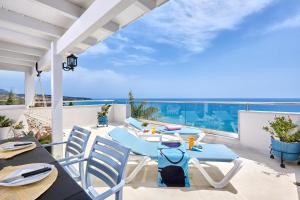 a patio with a table and chairs and a view of the ocean at Breathtaking sea view flat for families in Crete in Keratokampos