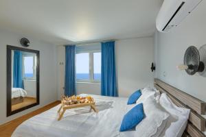 a bedroom with a large bed with blue curtains at Breathtaking sea view flat for families in Crete in Keratokampos