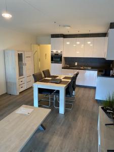 a kitchen with a table and chairs in a room at Studio 405 op zeedijk met frontaal zeezicht 4de verdiep in Middelkerke