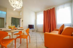 a living room with a table and orange chairs at Truly Verona in Verona