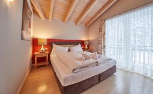 a bedroom with a large bed and a large window at Hüttl Relax Appartements in Saalbach Hinterglemm