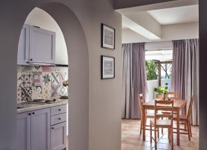 a kitchen and dining room with a table and chairs at Nemesis Aparthotel in Laganas