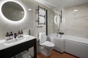 a bathroom with a sink and a tub and a toilet at Hotel Kakola in Turku
