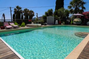- une grande piscine d'eau bleue dans la cour dans l'établissement B&B Val D'azur, à Carqueiranne