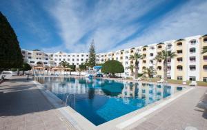 a large swimming pool in front of a large building at Thapsus Beach Resort in Mahdia
